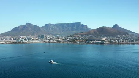 sailboat traveling towards the seaport of cape town with a view of the signal hill and table mountain in south africa