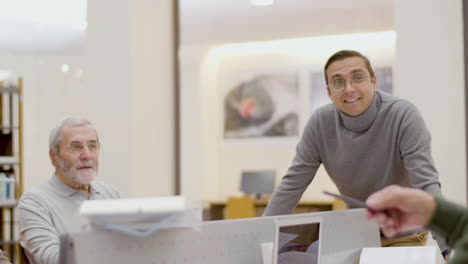 Young-teacher-having-class-with-senior-people-in-library