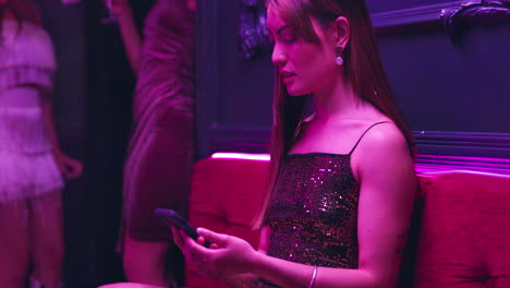 woman in a nightclub using a smartphone