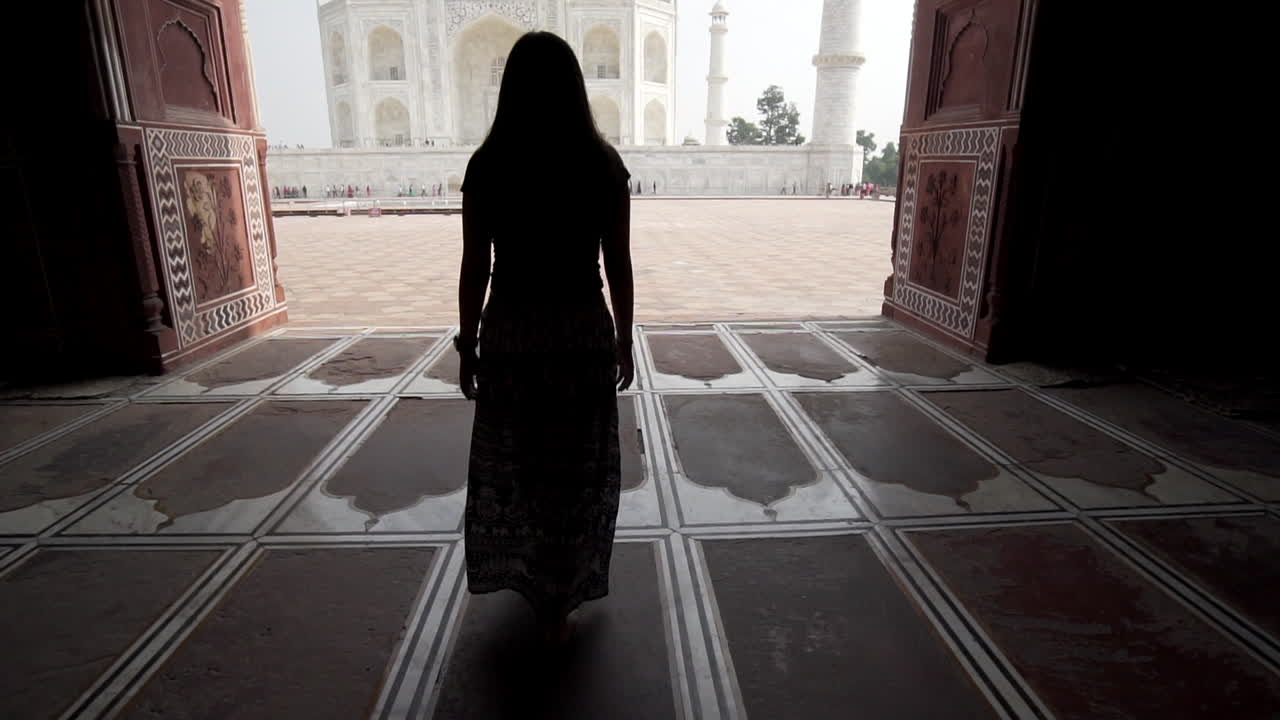 mujer vestida caminando hacia el taj mahal