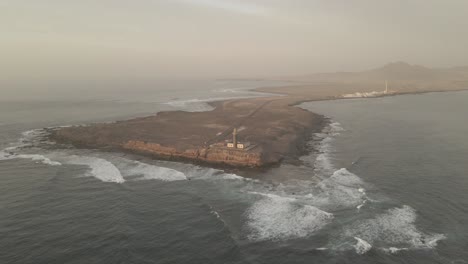 Drone-footage-captures-the-magic-of-a-cliffside-lighthouse-against-the-backdrop-of-crashing-waves—a-maritime-marvel-that-inspires-awe-and-wonder,-evoking-a-sense-of-adventure-and-exploration