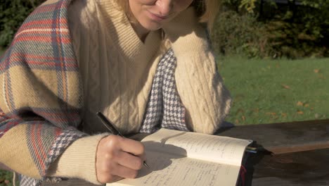 estudiante estudiando escritura al aire libre con suéter