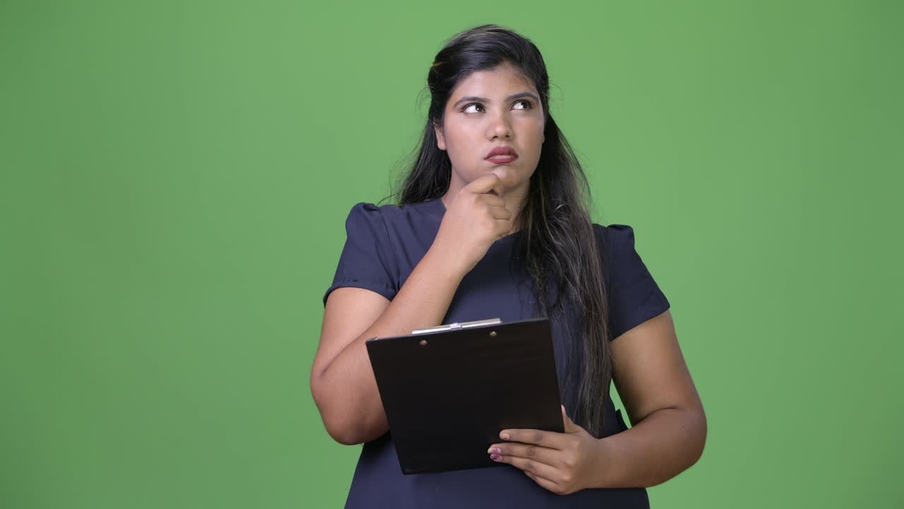 joven sobrepeso hermosa mujer de negocios india contra fondo verde
