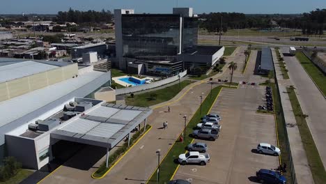 slow aerial descending shot of hotel and people walking to parking lot