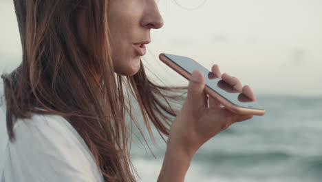 caucasian woman recording voice message outdoors