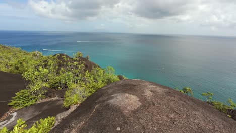 beautiful-view-from-granite-rock-boulders-to-the-ocean-of-Anse-major-nature-trail,-passion-boats,-turqoise-water,-Mahe-Seychelles