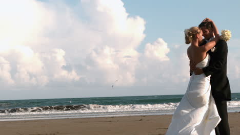 beautiful newlywed couple hugging on the beach