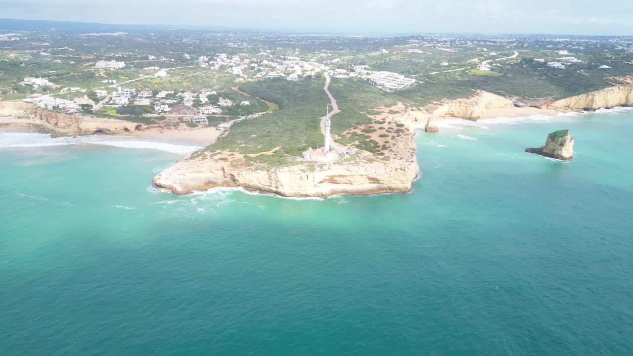 Ferragudo in algarve, portugal with scenic coastline and lighthouse , aerial view