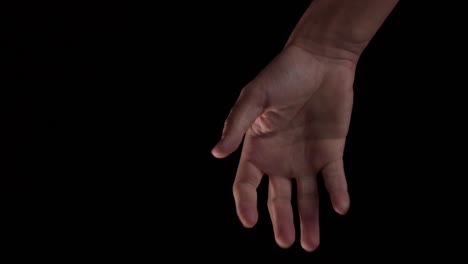 a human hand opening and closing, making a fist with a dark background