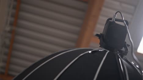 led video light with big soft box mounted high up on tripod, low angle