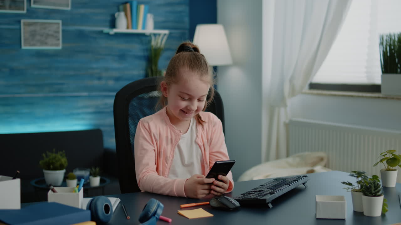 Young girl using smartphone with touch screen at desk