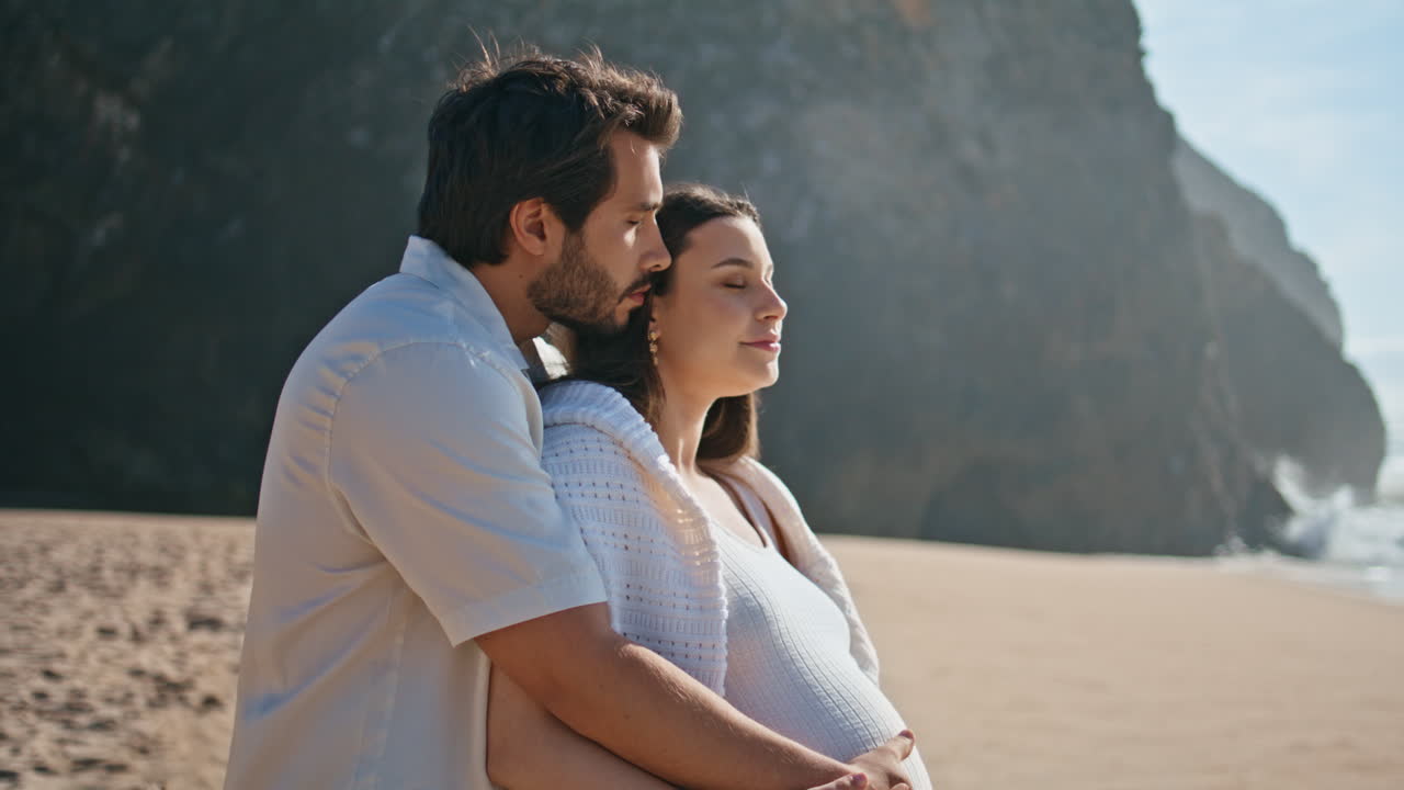 임신 한 커플 이 바다 풍경 을 바라보며 서 있는 모래 해변 여름 휴가 클로즈업