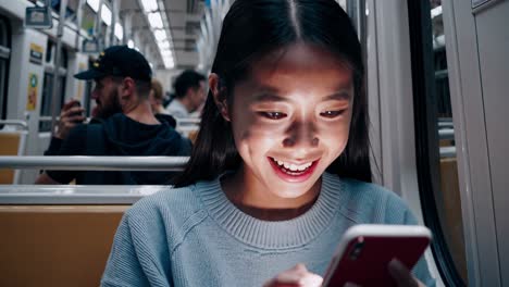 joven en un tren usando un teléfono inteligente
