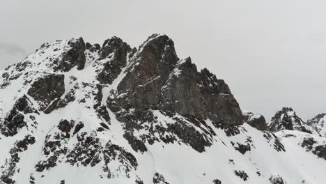 Schroffer,-Schneebedeckter-Berggipfel-An-Einem-Bewölkten,-Nebligen-Tag