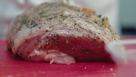 un pedazo de carne sazonado con condimentos está listo para hornear