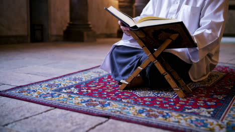 hombre musulmán leyendo el corán en una mezquita