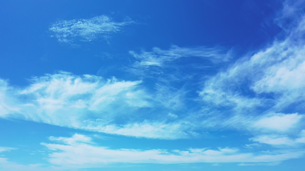 Peaceful blue heaven with veil of white clouds hanging over Atlantic ocean, freedom symbol, copy space