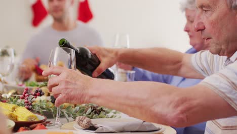 caucasian man pouring wine in his glass