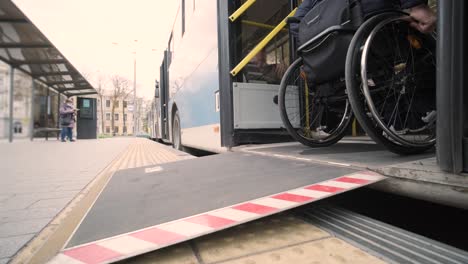 person with a physical disability enters public transport with an accessible ramp