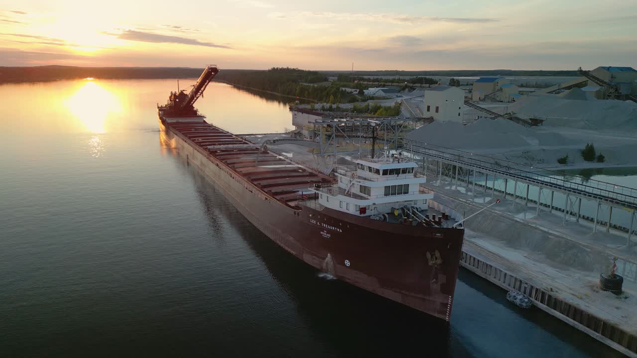 Aerial view of great lakes freighter with sunset behind it at quarry docks