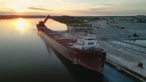aerial view of great lakes freighter with sunset behind it at quarry docks
