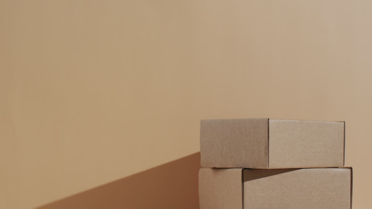 갈색 배경 위에 복사 공간이 있는 쌓인 카드보드 상자의 비디오