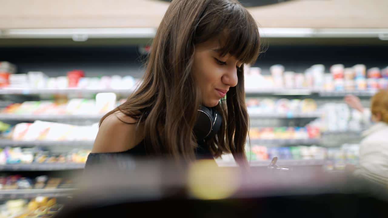 가게에 있는 한 소녀가 선반에서 제품을 가져가는 클로즈업 영상