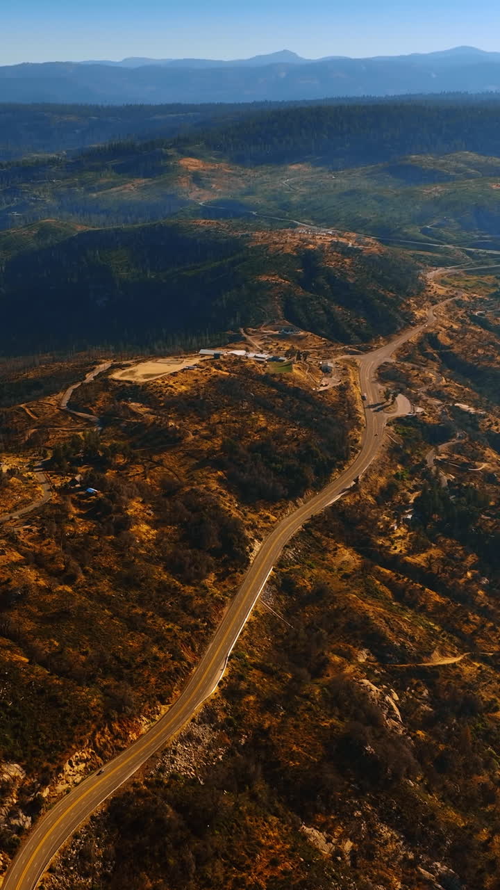 Rare houses in the bare rocks of Sierra National Forest, California, USA. Highways crossing the mountains. Top view. Vertical video