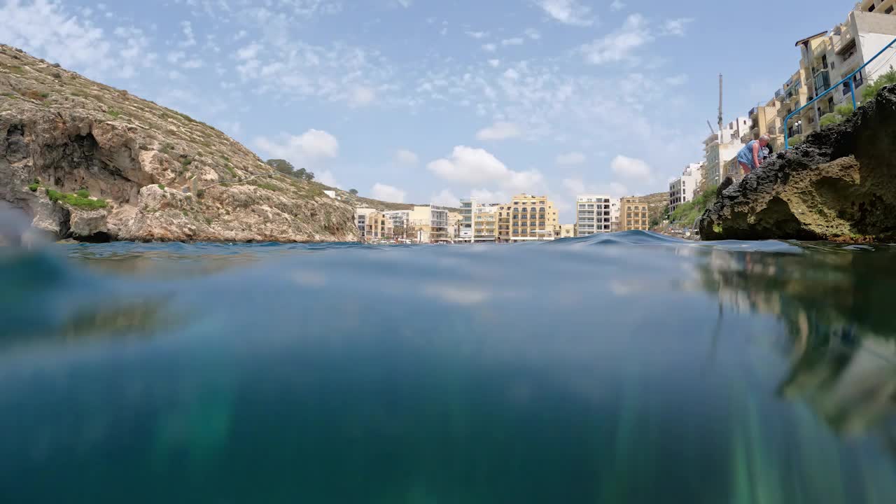 S close-up of a popular swimming, snorkeling, and diving place and a perfect diving site, in the water of Xlendi Bay on Gozo's southwest coast