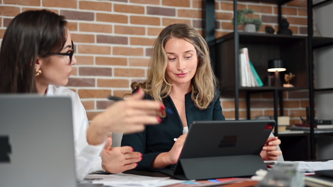 Coworkers analysing building plans and colours in an office
