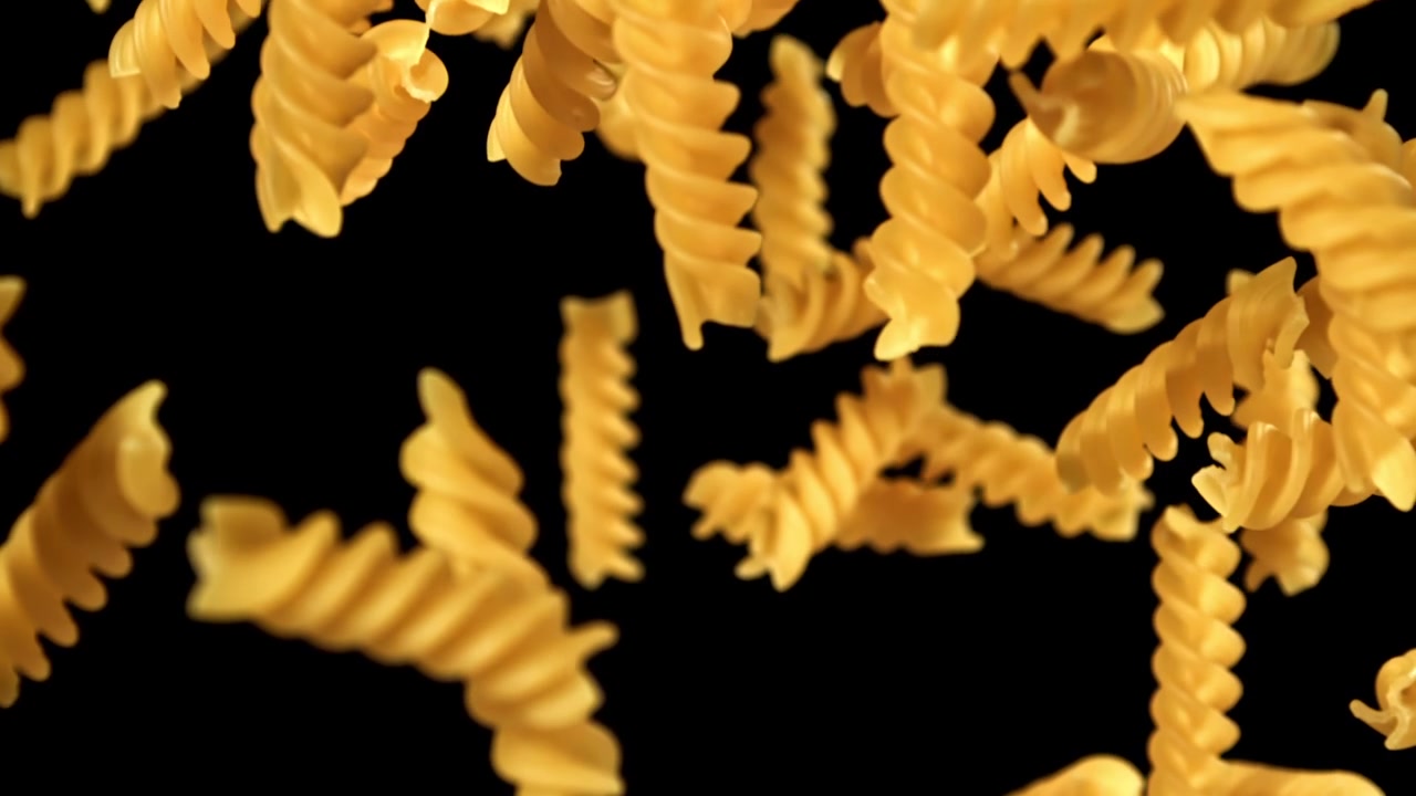 Raw Fusilli Pasta Falling in Slow Motion Against Black Background