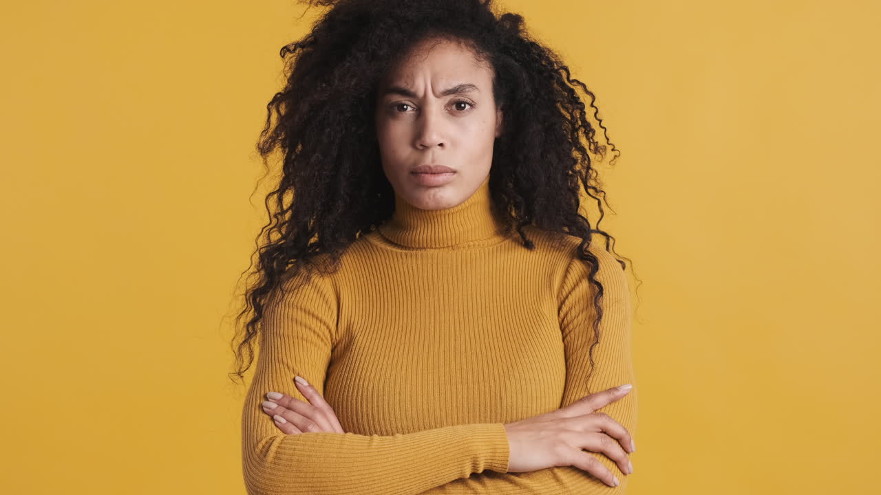 African american angry woman over orange background.