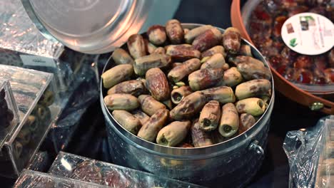 close-up view of a metal container filled with dates, a popular middle eastern fruit, at a market.