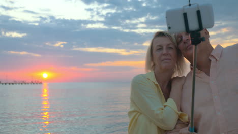 Couple-on-vacation-taking-selfie-at-sunset