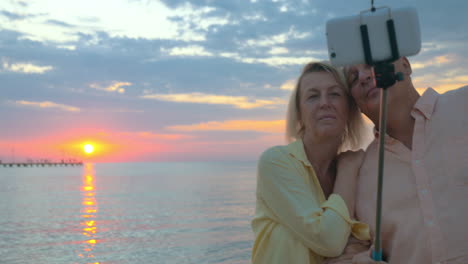 una pareja de vacaciones tomando una selfie al atardecer.