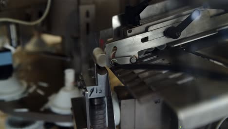 máquina automática de llenado y sellado de tubos para cremas cosméticas - tubos de plástico vacíos del cargador colocados en el molde del tubo por el túnel