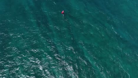 Advanced-wing-foiler-riding-upwind-into-deep-ocean,-Hookipa-Maui-overhead-aerial