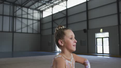 teenage female gymnast performing at sports hall