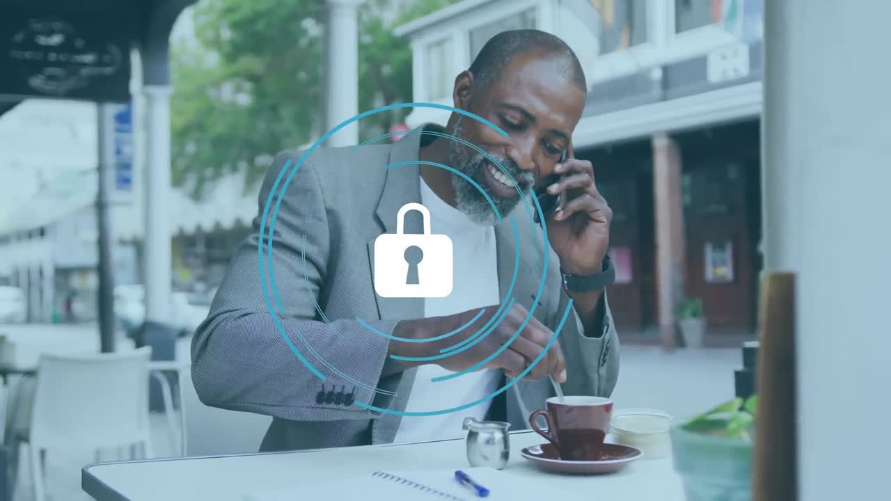 Animation of padlock with circles over african american man talking on cellphone and mixing coffee