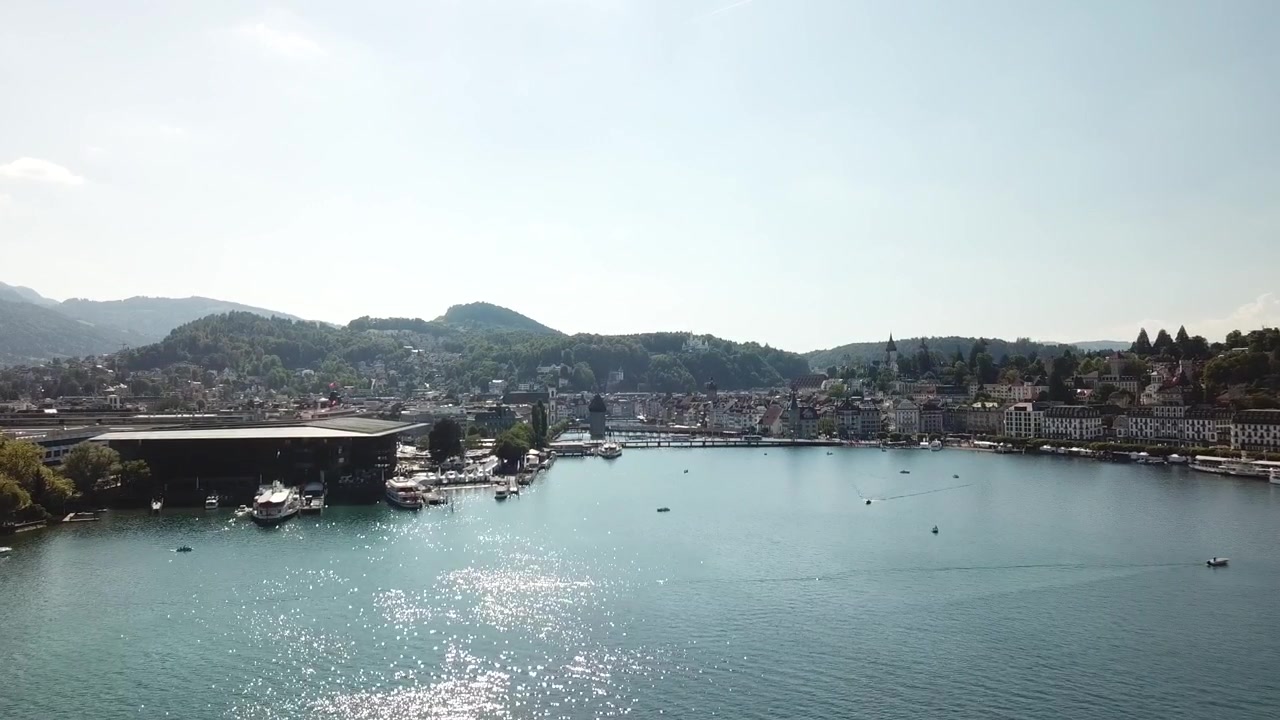 Un drone scende verso il centro di Lucerna, avvicinandosi al lungolago, all'edificio KKL e alla foce del fiume dall'alto.