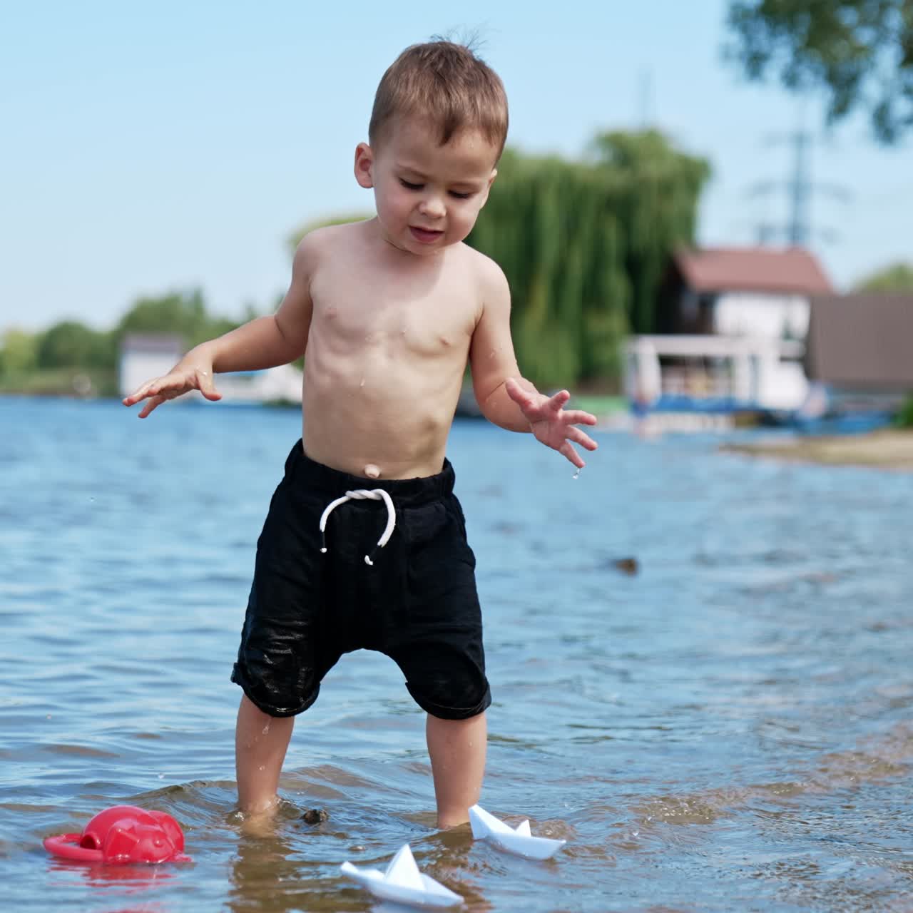 Summer water pond playground. Child playing on a river beach