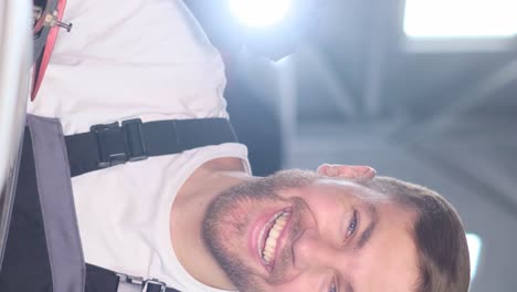 a man inspecting a vehicle with a flashlight and smiling