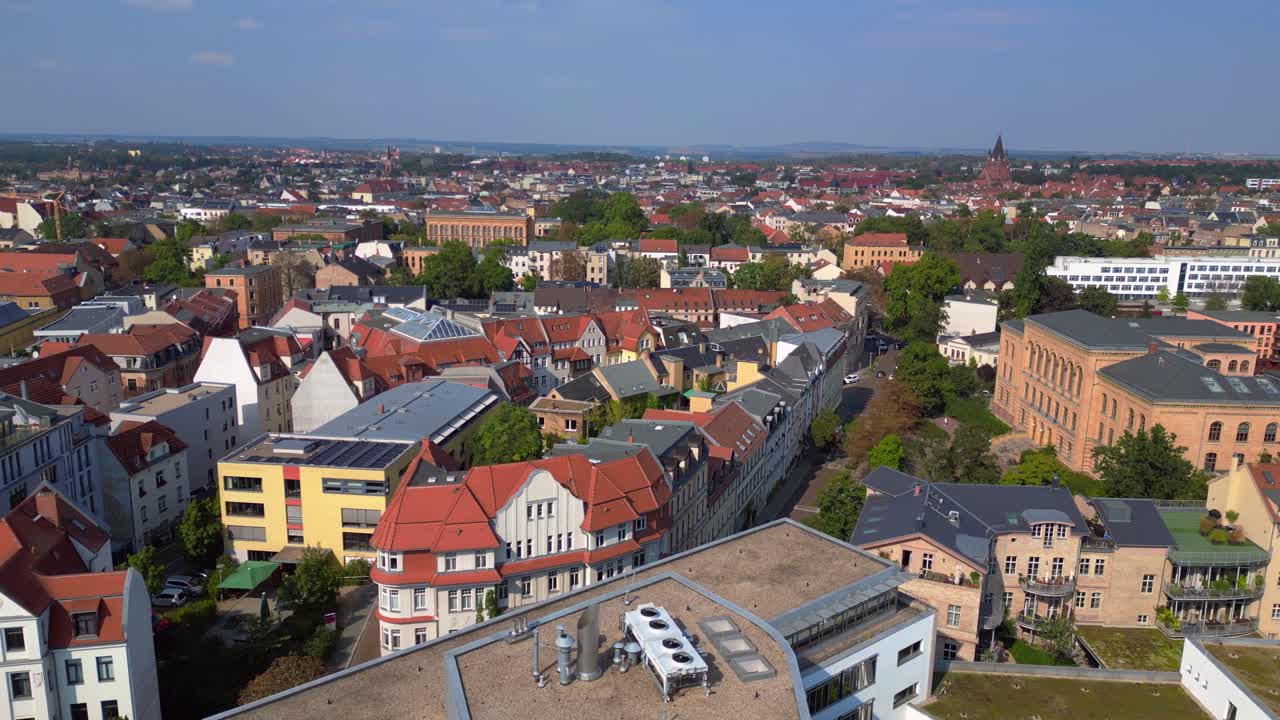 halle saale with the red brick building of the library surrounded by trees and houses, in germany. Stunning aerial view flight rotation to right drone