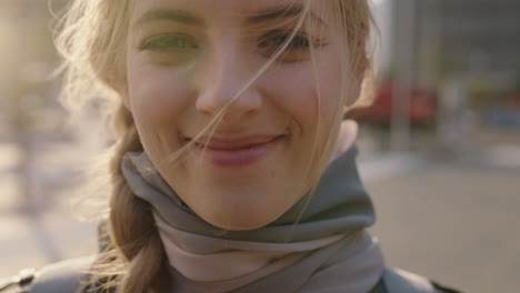 close up slow motion portrait of cute young blonde woman laughing at camera running hand through hair enjoying sunset in urban city commuting