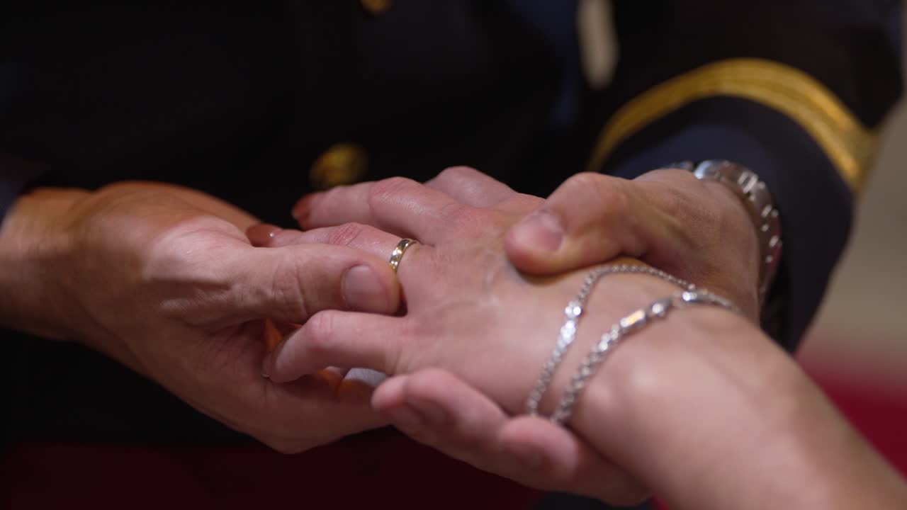 Close up of hands exchanging wedding rings during an emotional ceremony