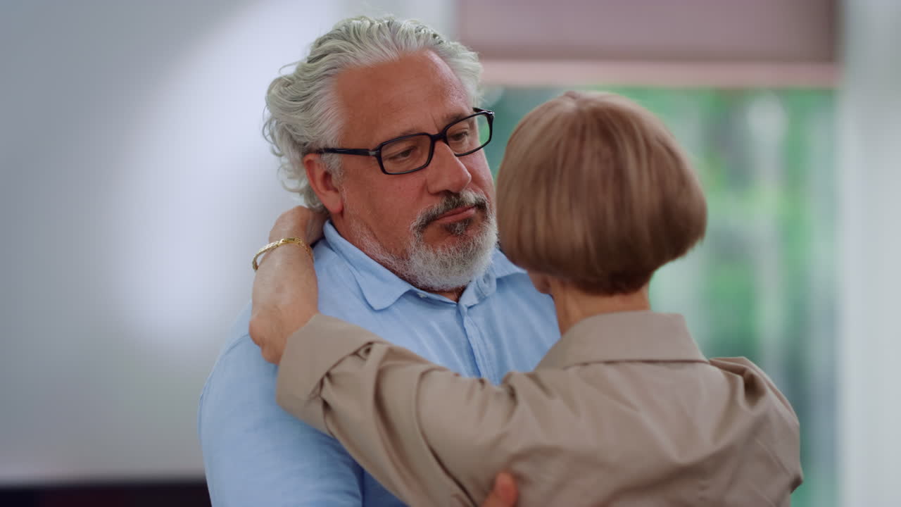 Senior man and woman dancing in pair at home. Couple looking at each other
