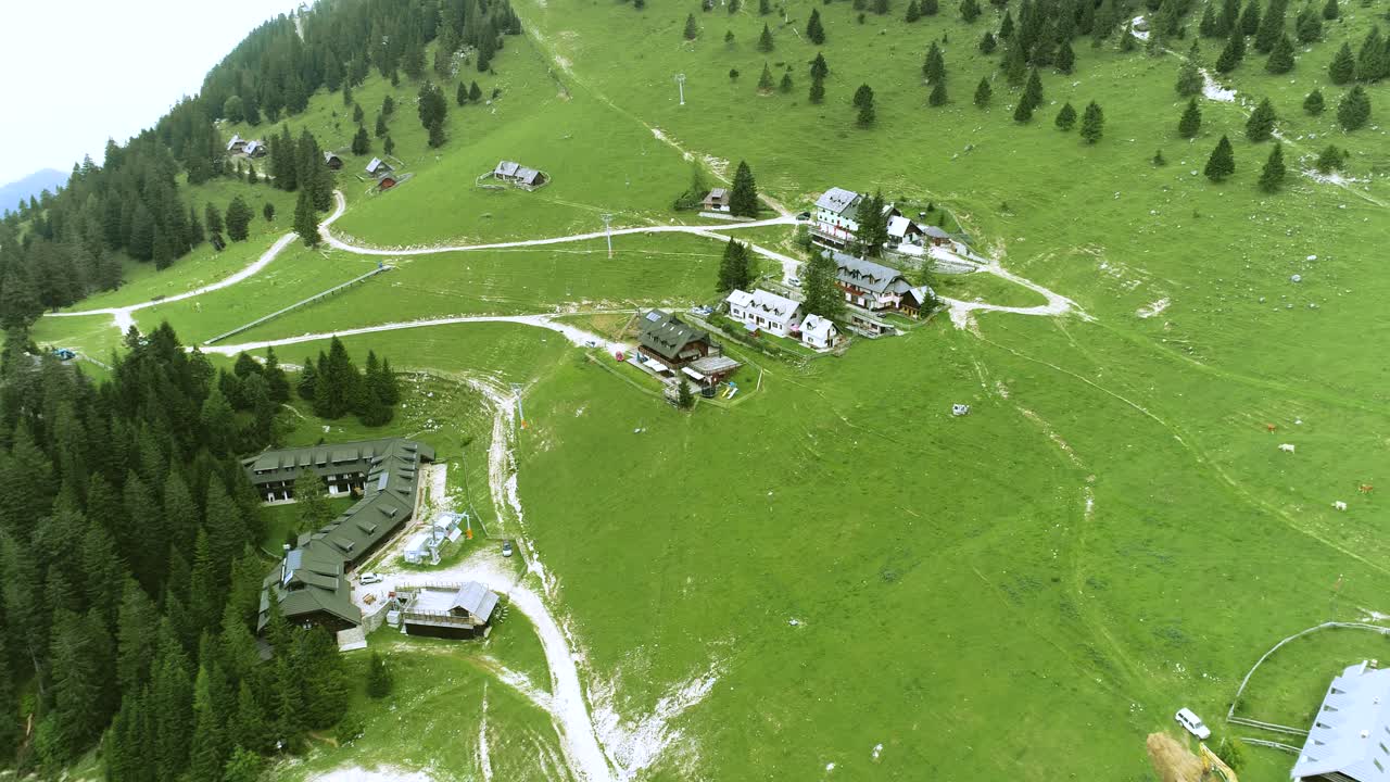 Krvavec ski sport resort surrounded by green and lush Alpine vegetation. Aerial zoom out