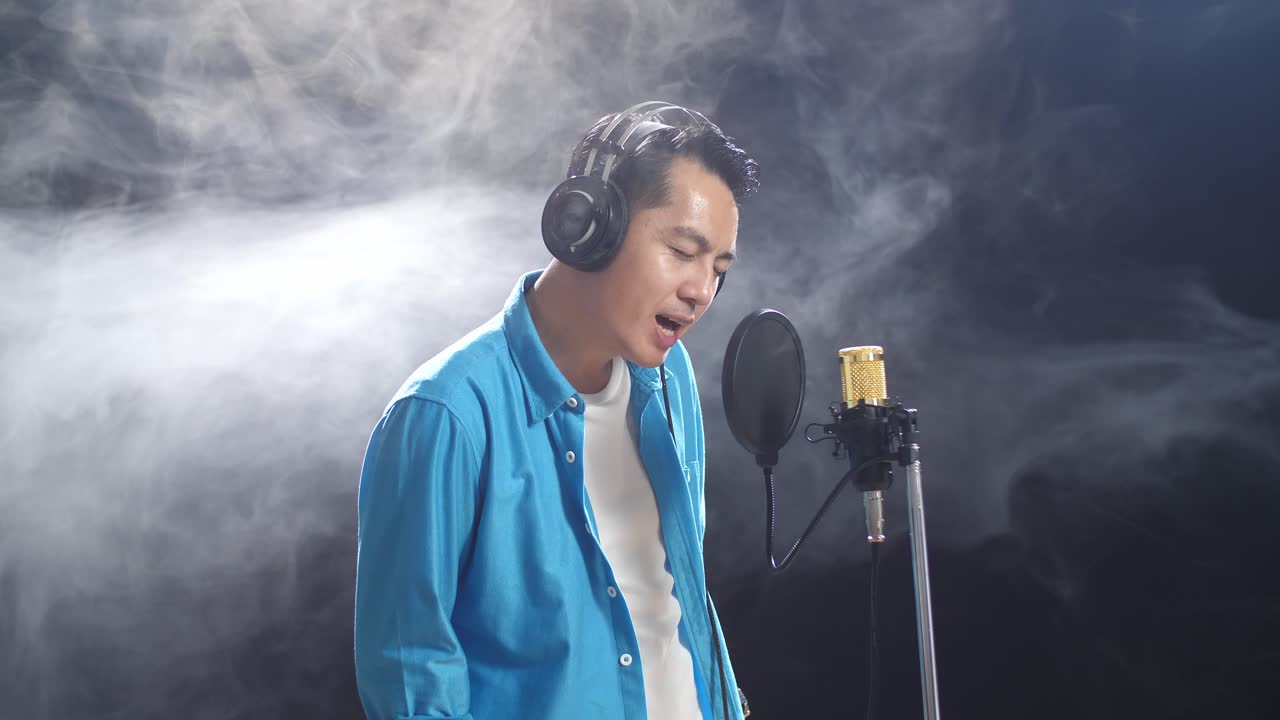 녹음 스튜디오 에서 마이크 로 노래 하는 남자