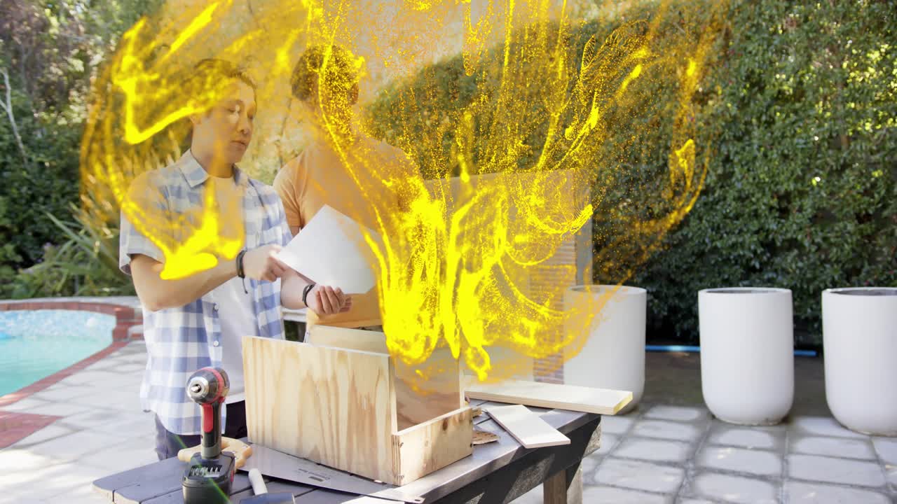 Mentor guiding teen examining plan and building box, yellow ribbon weaving around hands and boards