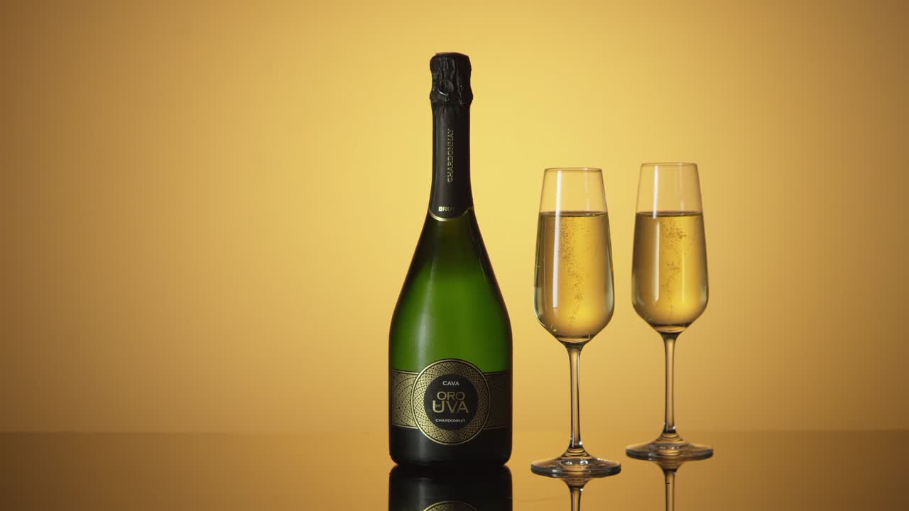 bottiglia di cava, vino frizzante con due bicchieri accanto